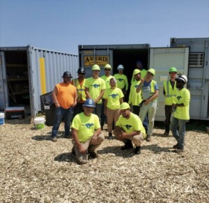 Image of the A-Verdi team in front of storage containers