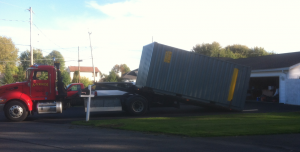 image of a truck dropping off a storage container