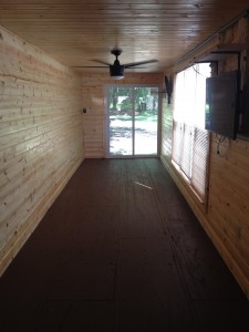 Image of the inside of a storage container with wood walls, windows and a fan