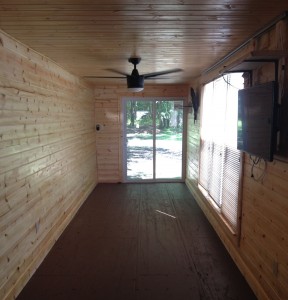 Image of the inside of a storage container with wood walls, windows and a fan