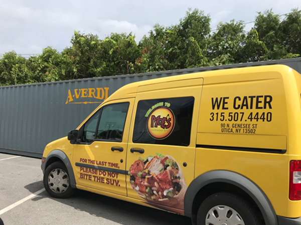 Image of a Moe's van in front of a storage container